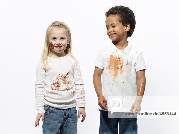 Two kids covered in chocolate sauce
