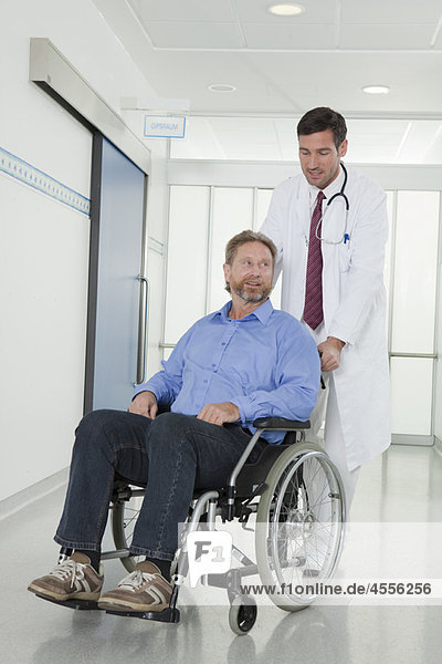 Arzt mit Patient im Rollstuhl