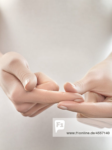 Woman pinching finger  close-up