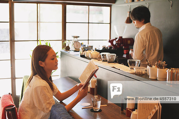 Japanese Woman Reading A Book in a Café