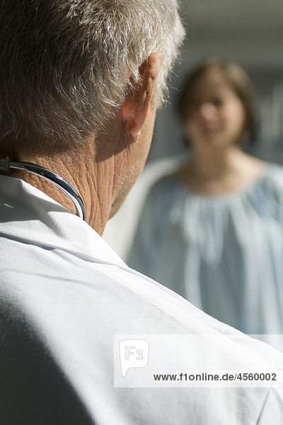 Doctor talking with patient  over the shoulder view