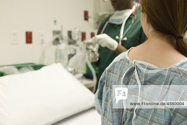 Patientenbeobachtung als Krankenschwester bereitet medizinische Geräte vor