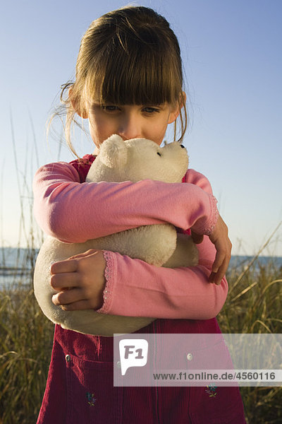 Junges Mädchen umarmt Plüschtier Eisbärenjunges