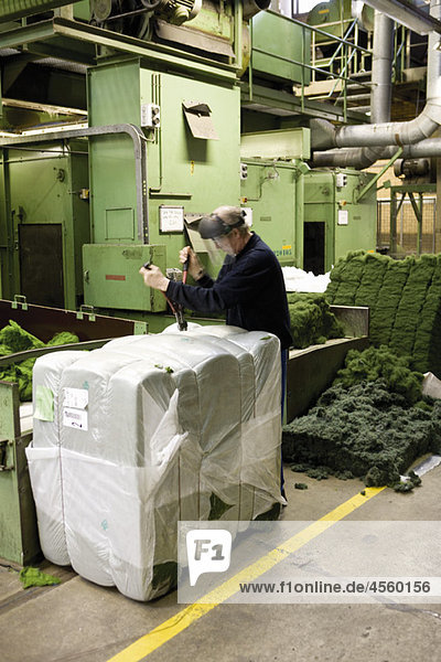 Textilarbeiter beim Auspacken von Materialien in der Teppichfliesenfabrik