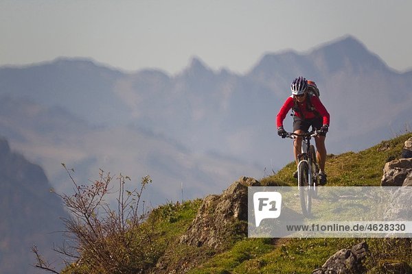 Austria  Tirol  Female mountain biker biking on spitzstein mountain