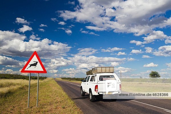 Afrika  Botswana  Landfahrzeug auf der Trans-Kalahari-Autobahn mit Verkehrszeichen
