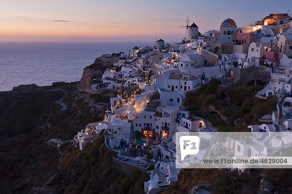 Griechenland  Kykladen  Thira  Santorini  Blick auf Oia und Windmühlen nach Sonnenuntergang