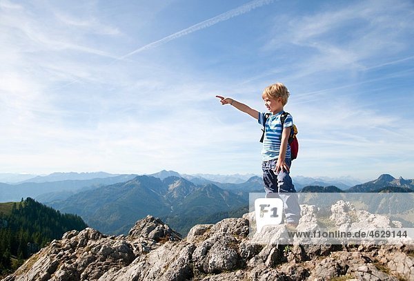 Junge (4-5 Jahre) auf dem Berggipfel mit Blick auf die Aussicht