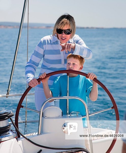 Kroatien  Zadar  Mutter und Sohn Steuerrad auf Segelboot