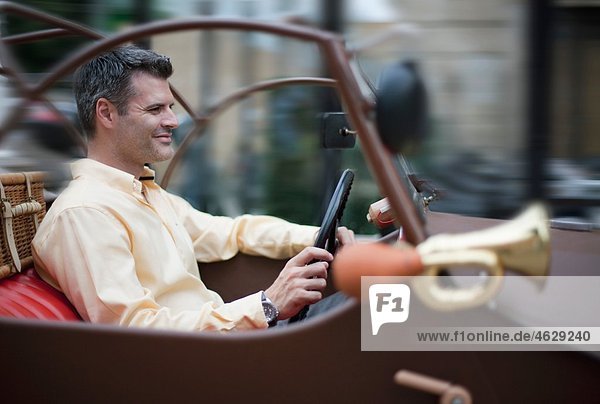 Kroatien Zagreb Mann im Oldtimer-Auto lächelnd