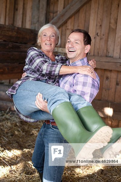 Man carrying woman at the farm  smiling