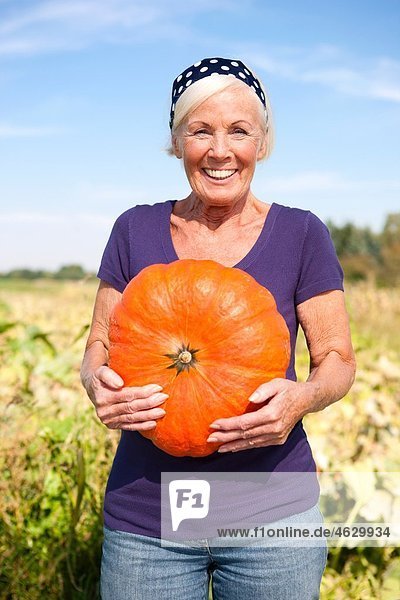 Seniorin mit Kürbis  lächelnd  Portrait