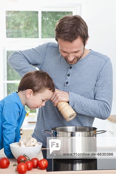 Germany  Bavaria  Munich  Father and son (2-3 Years) preparing meal in kitchen