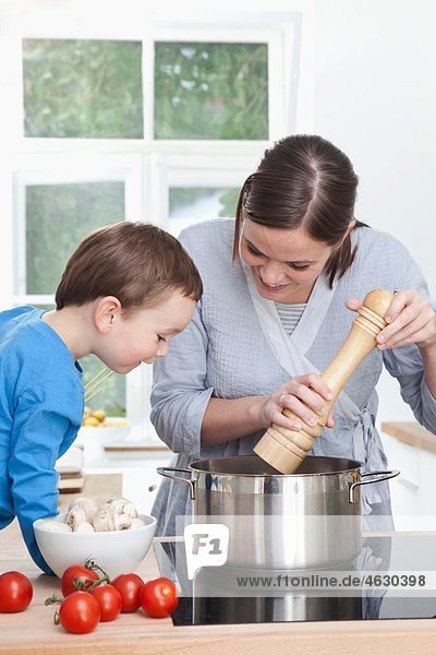 Deutschland  Bayern  München  Mutter und Sohn (2-3 Jahre) bereiten das Essen in der Küche vor.