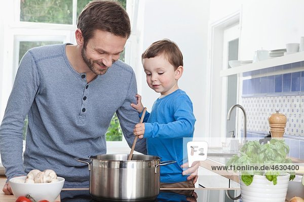 Deutschland  Bayern  München  Vater und Sohn (2-3 Jahre) bereiten das Essen in der Küche vor.