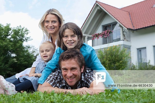Deutschland  München  Familie vor dem Haus  lächelnd  Portrait