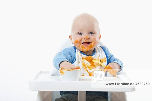 Babyboy (6- 11 Monate) beim Spielen mit Babynahrung