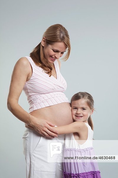 Tochter hört auf schwangeren Muttermagen