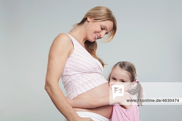 Tochter hört auf schwangeren Muttermagen