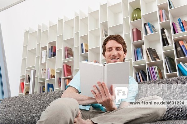 Man sitting on sofa and holding book