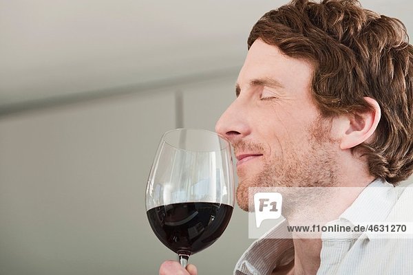 Man tasting the wine in kitchen