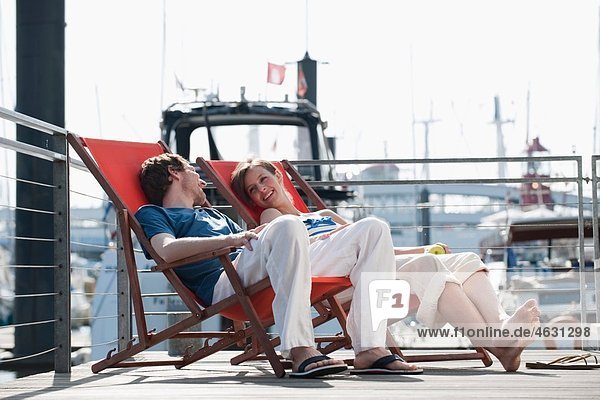 Deutschland  Hamburg  Paar entspannt im Liegestuhl auf dem schwimmenden Haus