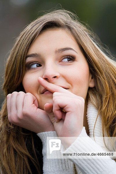Young woman is mimicking ´silence´ with a finger