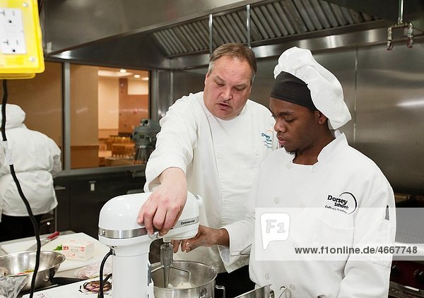 Roseville  Michigan - Instructor John Adamski works with a student preparing food at the Dorsey Culinary Academy  a private career training school