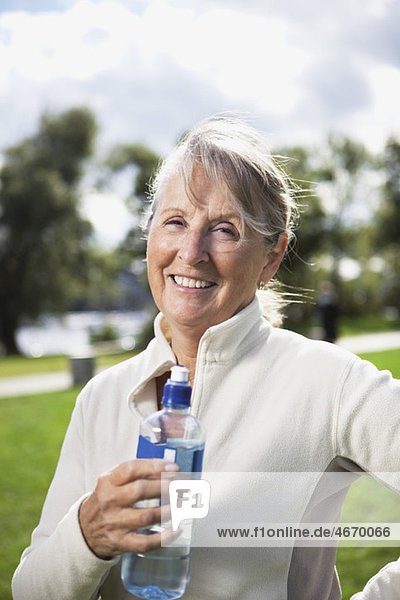 Glückliche Frau mit Wasserflasche