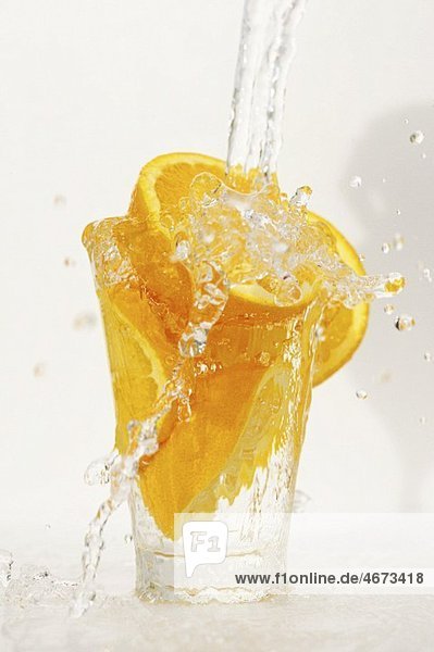 Orangen in einem Glas mit Wasser