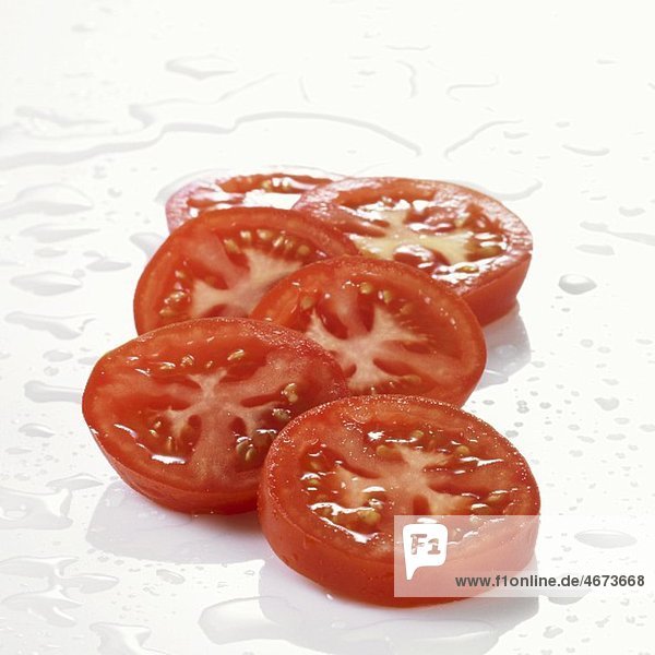 Mehrere Tomatenscheiben mit Wassertropfen