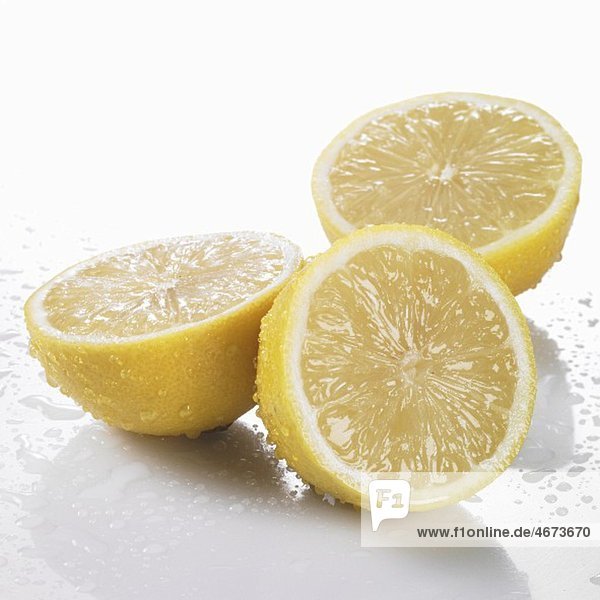 Drei Zitronenhälften mit Wassertropfen
