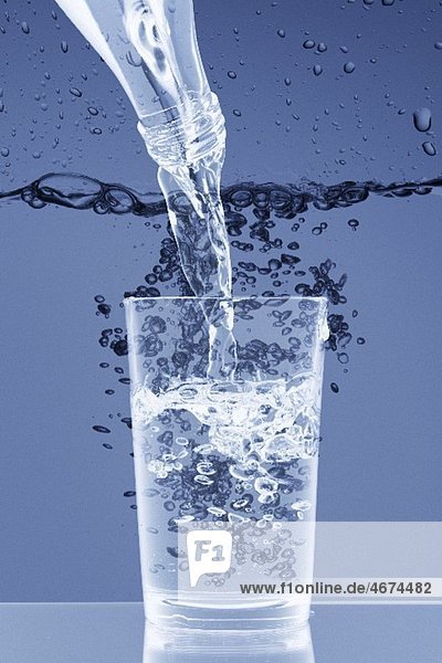 Wasser aus Flasche in Glas giessen