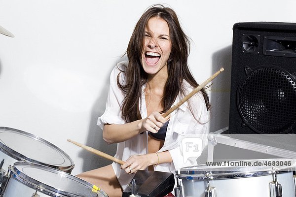 Junge Frau spielt Schlagzeug