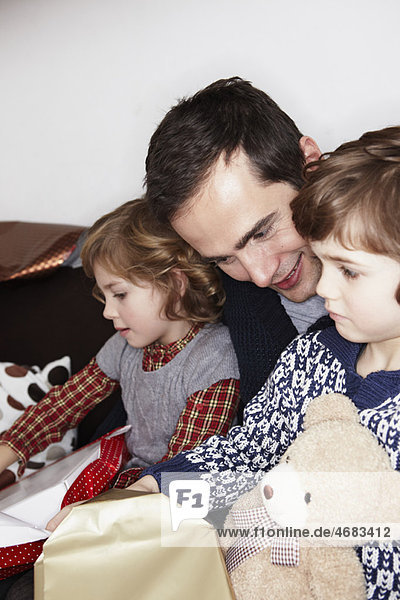 Man with two Kids opening gifts