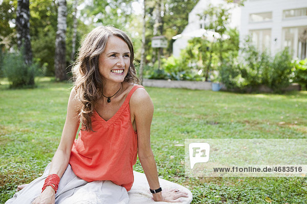 Smiling woman sitting in garden
