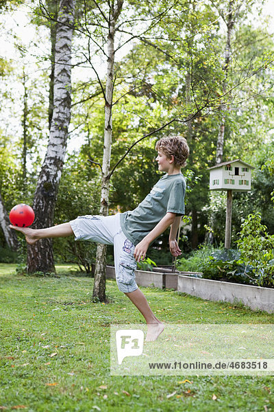 Boy playing with ball in the garden