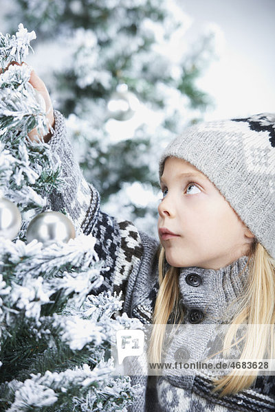 Girl decorating a christmas tree