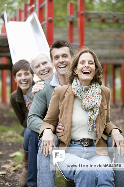 Familienportrait auf einer Rutsche im Park