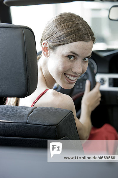 Lächelnde junge Frau in einem Auto