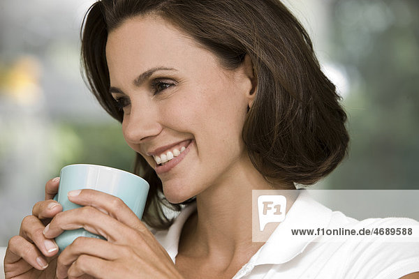 Lächelnde Frau hält eine Kaffeetasse