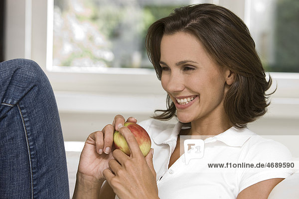Lächelnde Frau hält einen Apfel