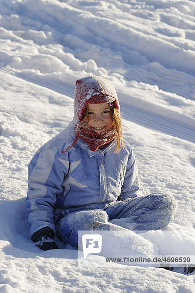 Child sitting in snow  powder snow