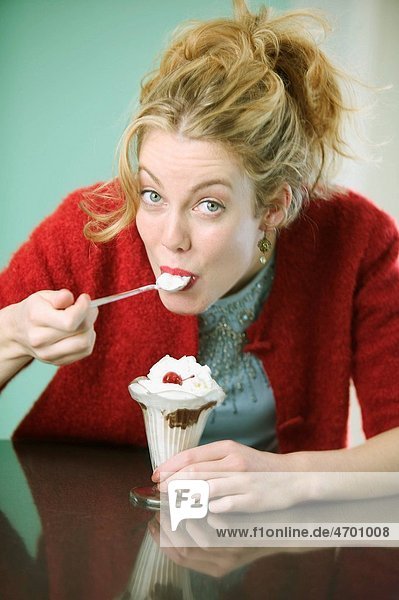 Woman eating a chocolate sundae.
