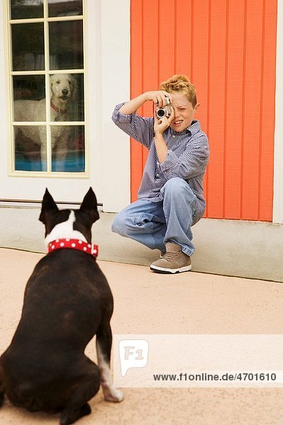 A boy photographing his dog