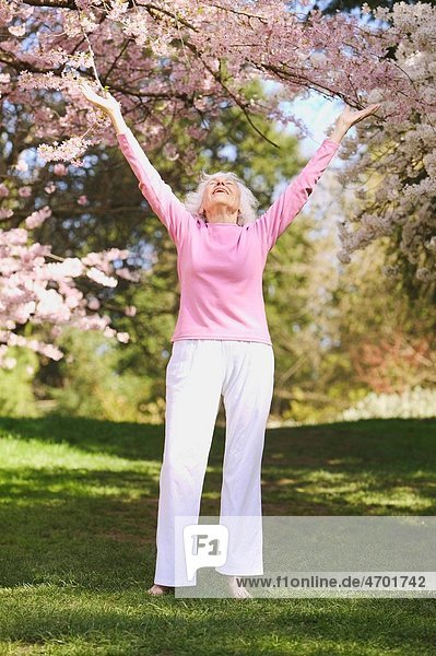 A senior woman with outstretched arms
