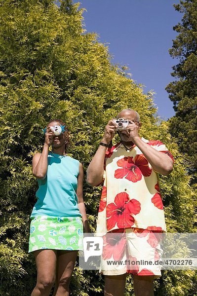 Couple with cameras taking pictures