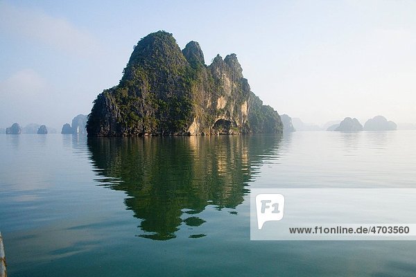 Rocky islands with still water in misty morning