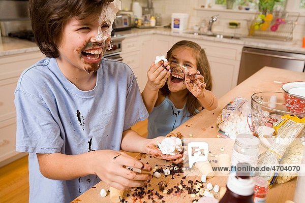 Boy and girl making mess in kitchen