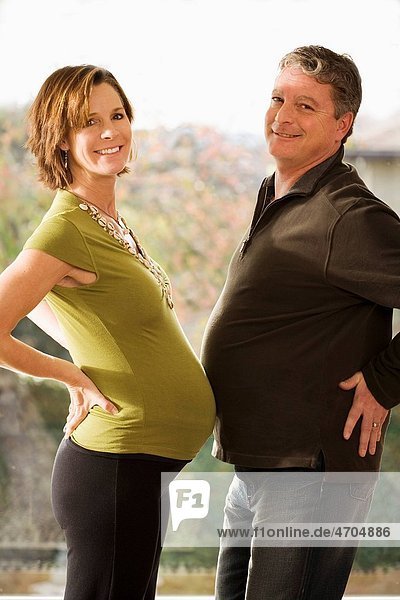 Portrait of pregnant couple touching bellies